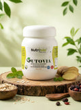 Nutravida Gutovia supplement jar on a wooden surface with natural ingredients in the background