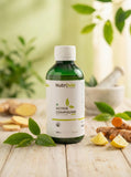 Nutravia Active Compound bottle on a wooden surface with ginger, lemon, and green leaves in the background.